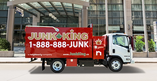 Red dump truck parked in front of a commercial building.